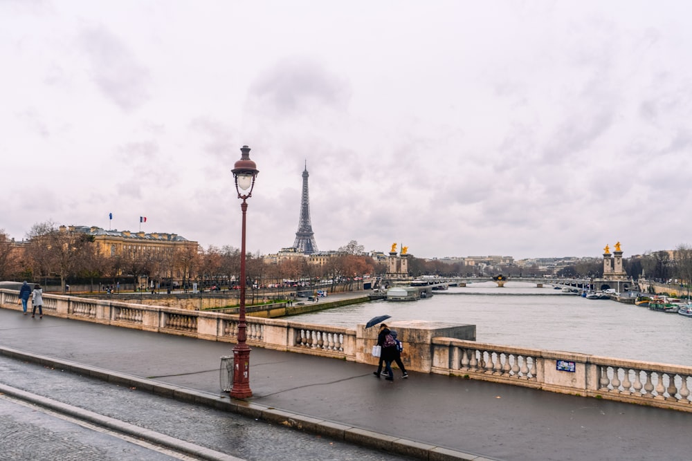 a couple of people walking across a bridge