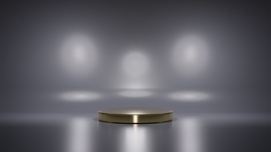 A metallic platform is centered in a minimalistic setting with a reflective surface. Soft, diffused lighting creates circular patterns on the background wall, enhancing the focus on the central stage. The ambiance is sleek and modern, with a hint of elegance.