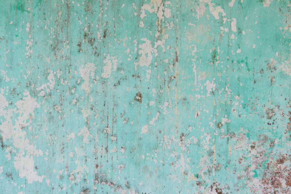 a green wall with rust and white paint