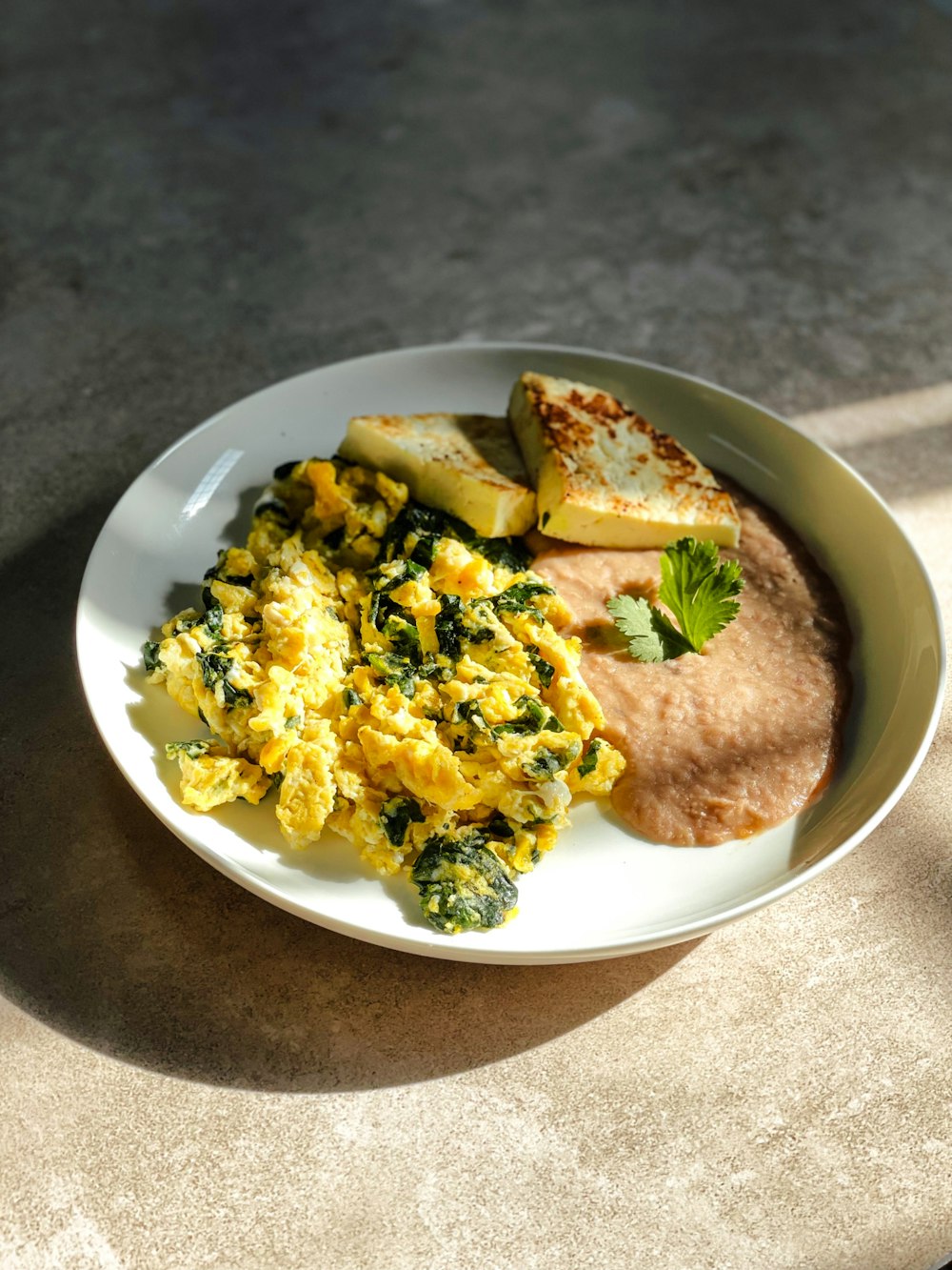 a white plate topped with eggs and vegetables