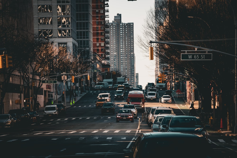 a city street filled with lots of traffic next to tall buildings