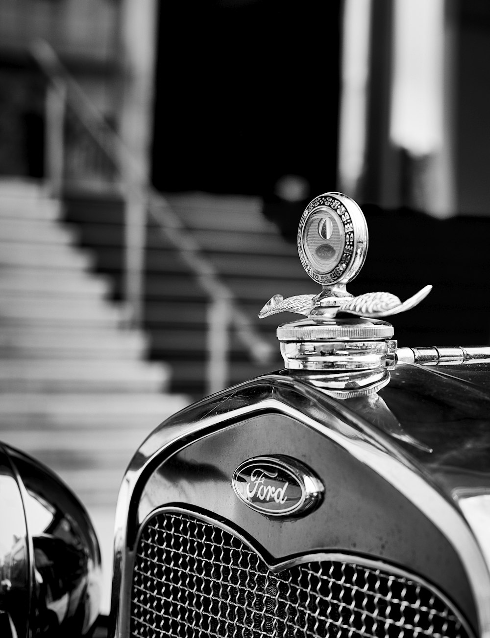 a classic car parked in front of a set of stairs