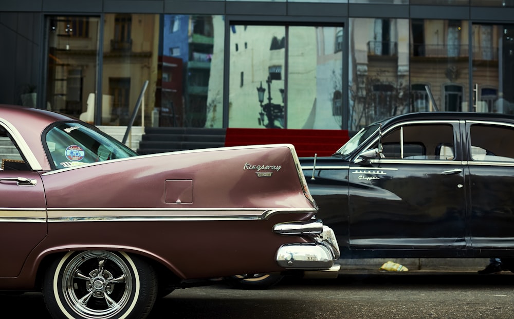 two old cars parked next to each other in front of a building