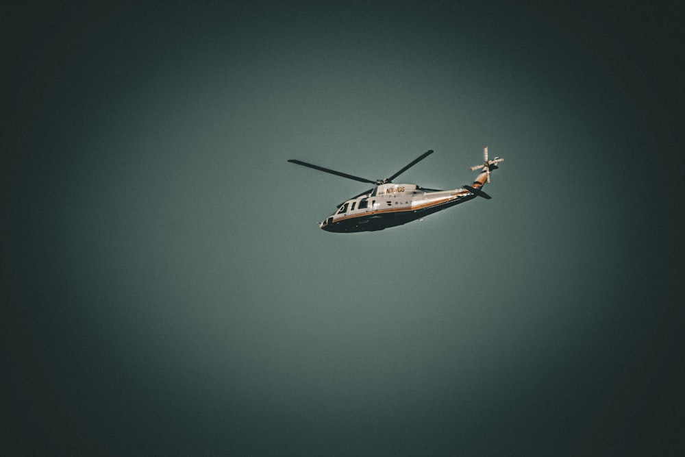 a helicopter is flying in the sky on a cloudy day