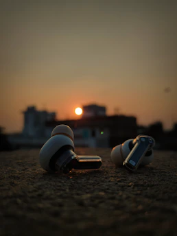 a couple of ear buds sitting on top of a sandy ground