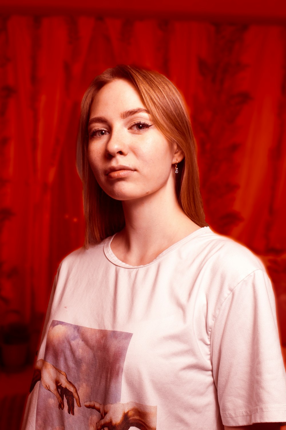 a woman standing in front of a red curtain