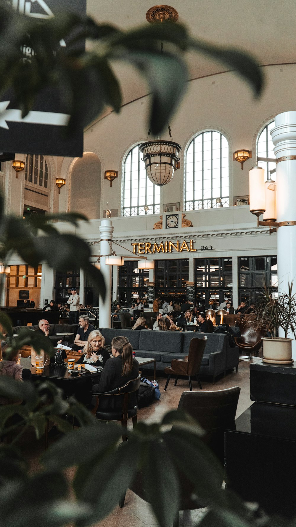 people sitting at tables in a large building