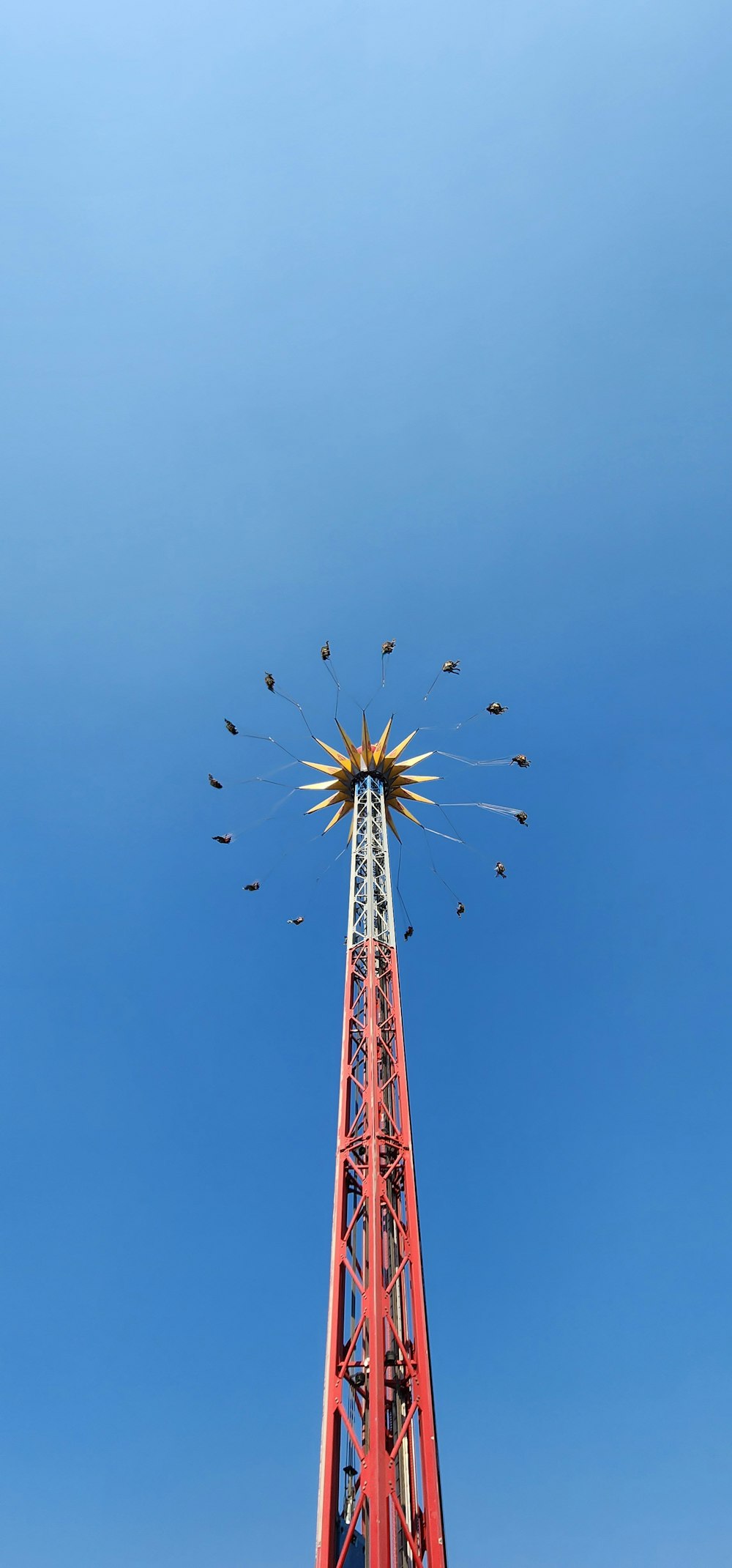 a tall tower with a bunch of birds on top of it