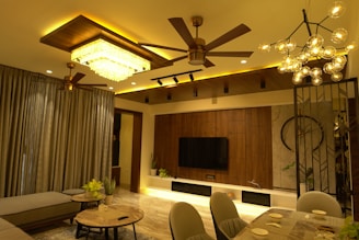 A cozy living room featuring a modern fan and a stylish lamp glowing warmly