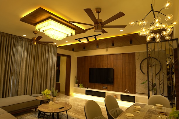 A cozy living room featuring a modern fan and a stylish lamp glowing warmly