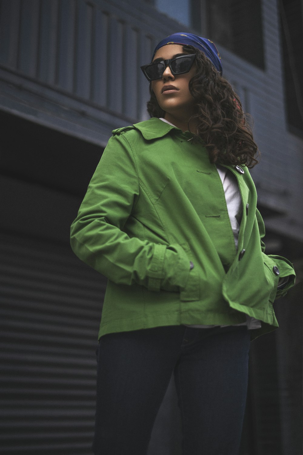 a woman wearing a green jacket and sunglasses