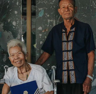 A Vitalis agent assisting a senior couple with paperwork in a cozy, welcoming environment.