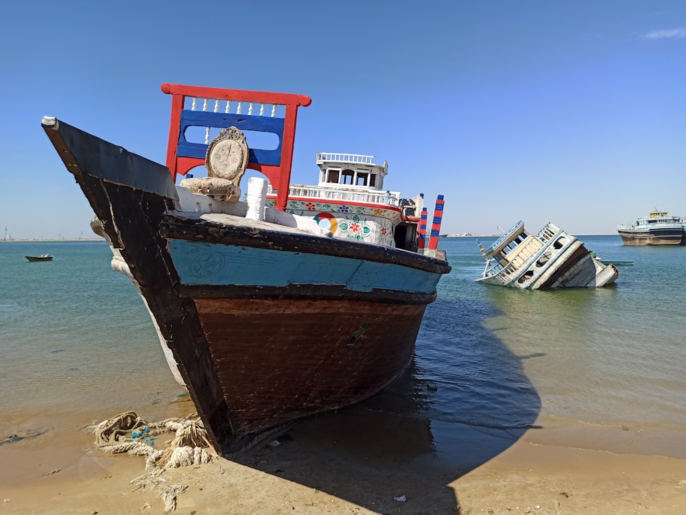 a boat sitting on top of a beach next to the ocean