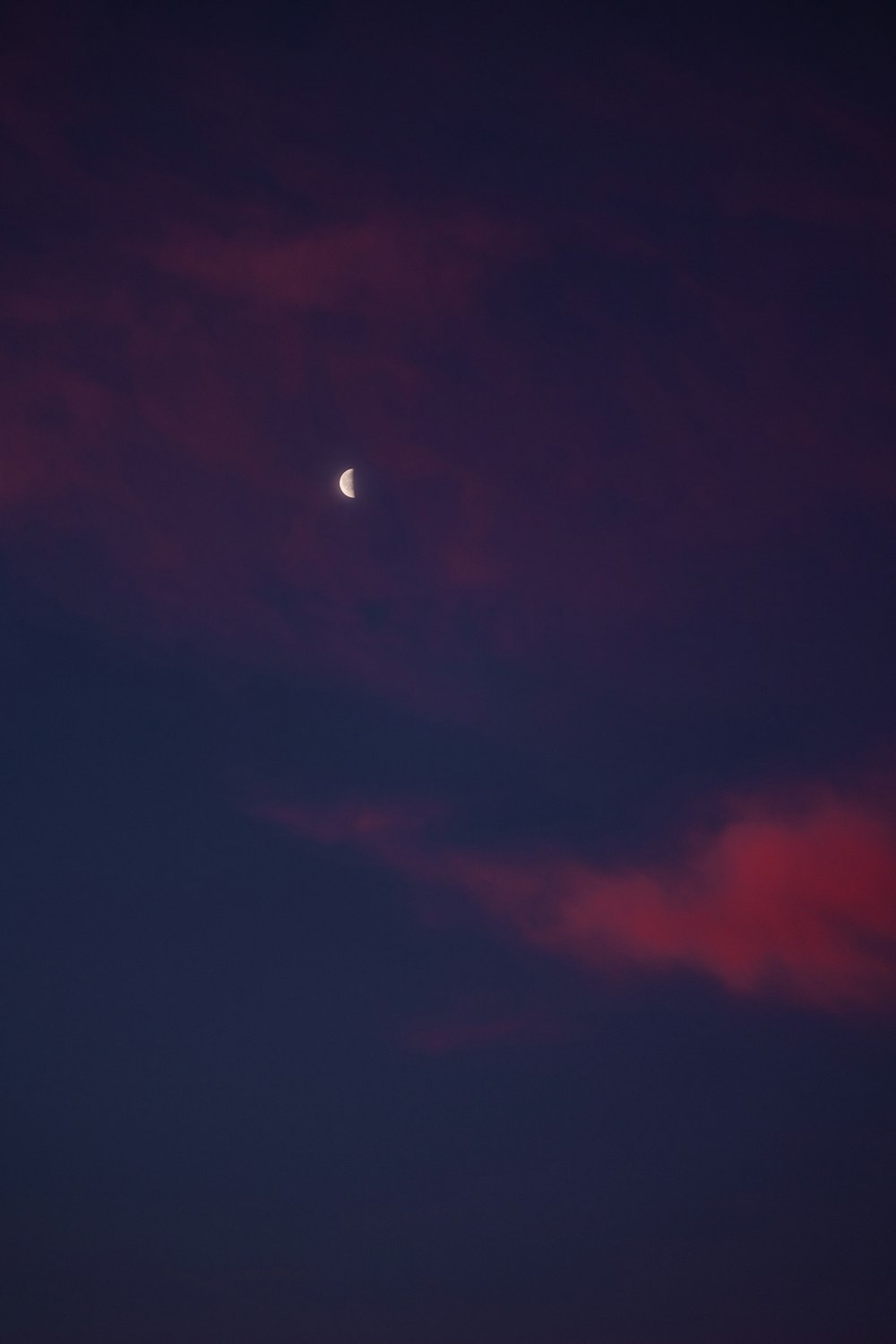 the moon is seen through the clouds in the night sky