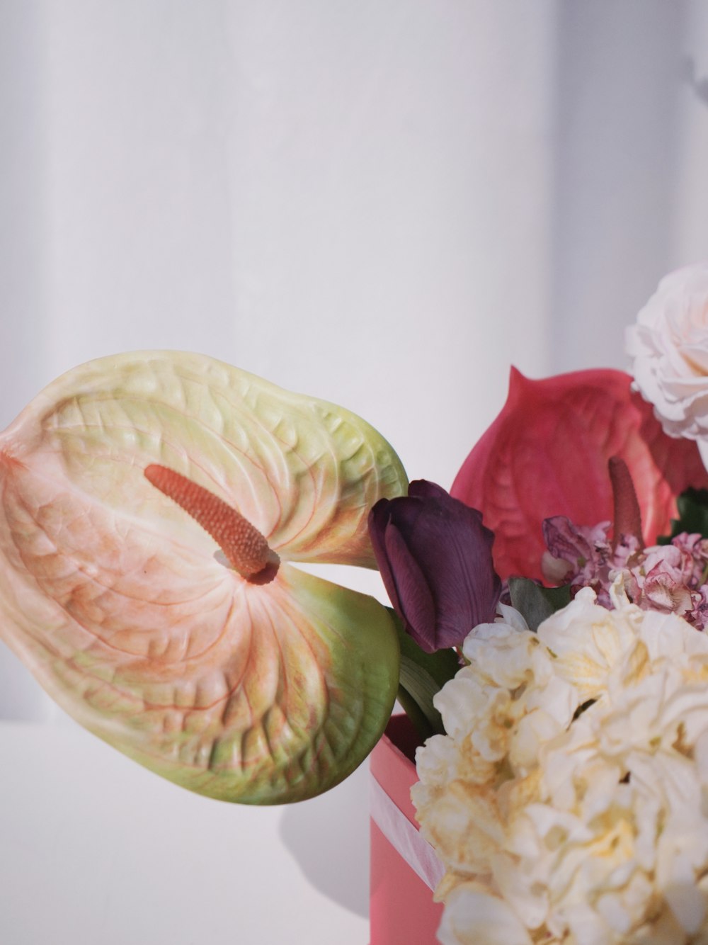 a flower arrangement in a pink vase on a table