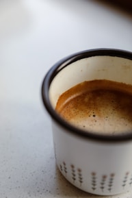Close-up of hands holding a steaming, custom-printed coffee mug with classic patterns.