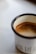 A stylish mug with a unique design placed next to a steaming cup of coffee.