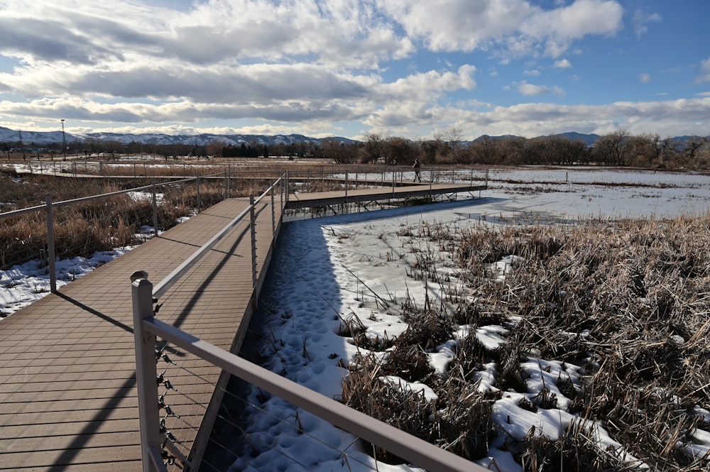 a wooden bridge over a frozen river