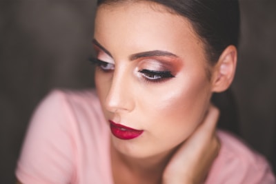 Elegant makeup featuring bold eyes and soft lips on a smiling woman.