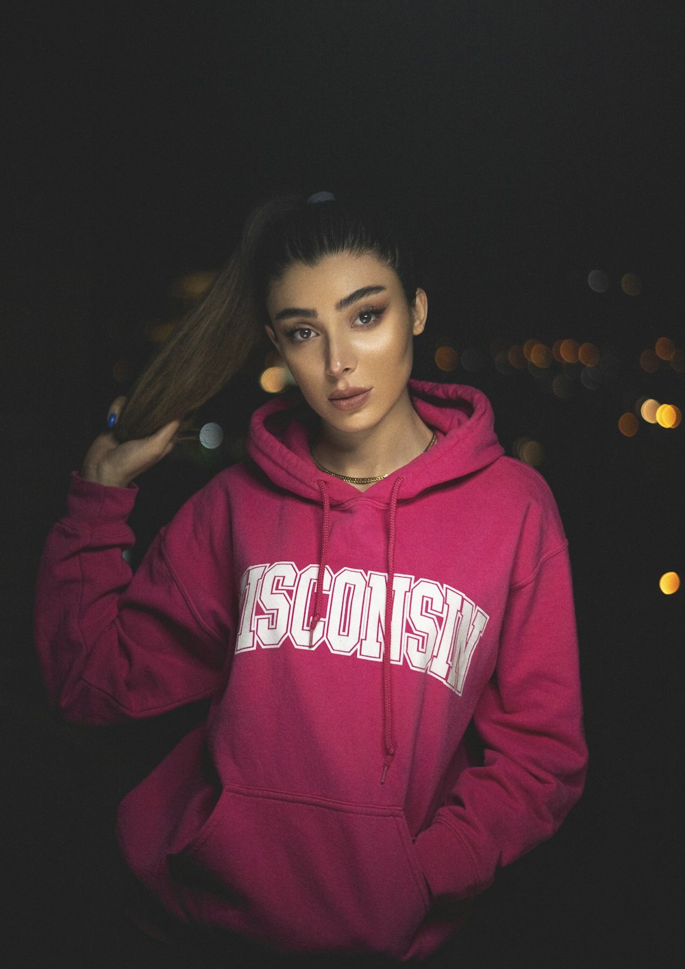 a woman in a pink hoodie posing for a picture
