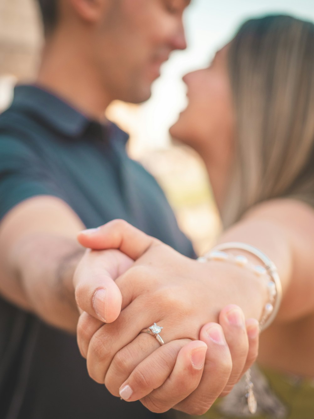 a close up of a person holding a woman's hand