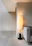 A warm-lit modern living room corner featuring a sleek uplight casting soft shadows.