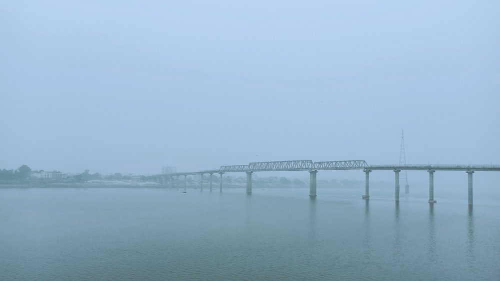 a bridge over a body of water on a foggy day