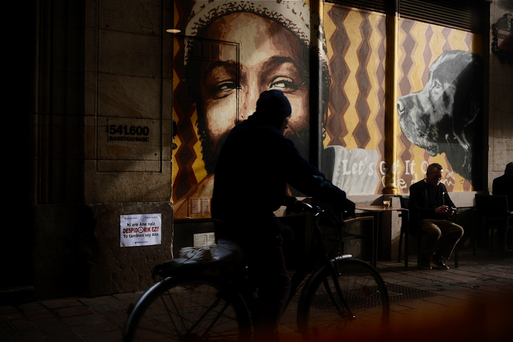 a man riding a bike down a street next to a building