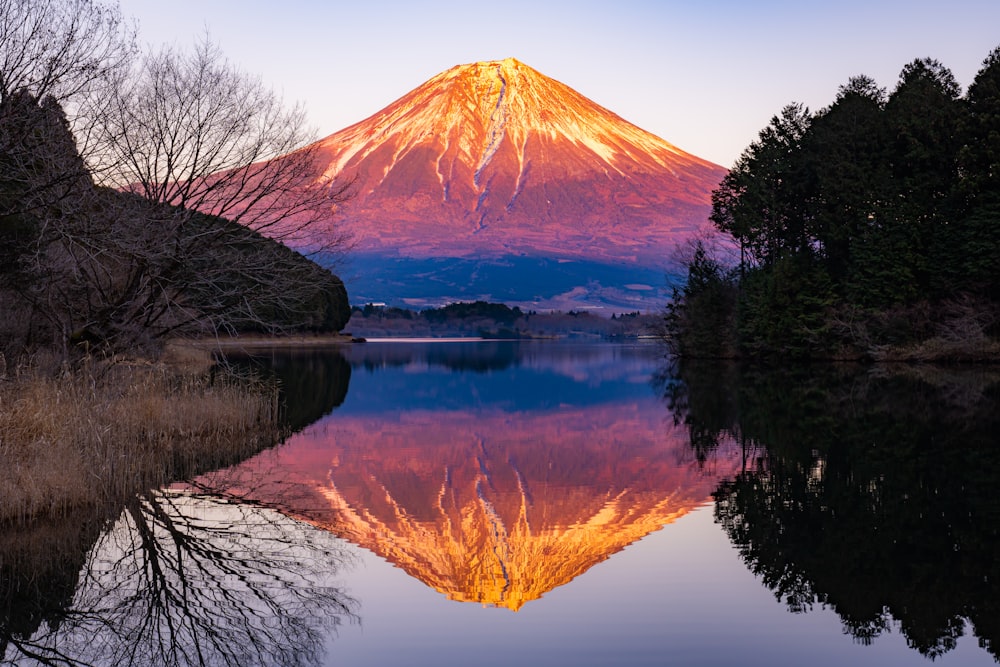 a mountain is reflected in the still water of a lake