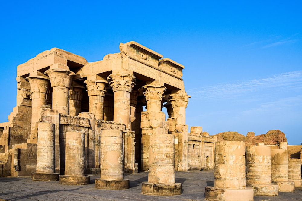 a group of stone pillars in front of a blue sky