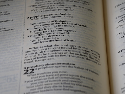 A close-up view of text from an open book, focusing on verses and prophecies from a religious script. The page numbers and chapters are visible, with some parts of the text emphasized in bold.