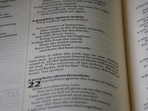 A close-up view of text from an open book, focusing on verses and prophecies from a religious script. The page numbers and chapters are visible, with some parts of the text emphasized in bold.