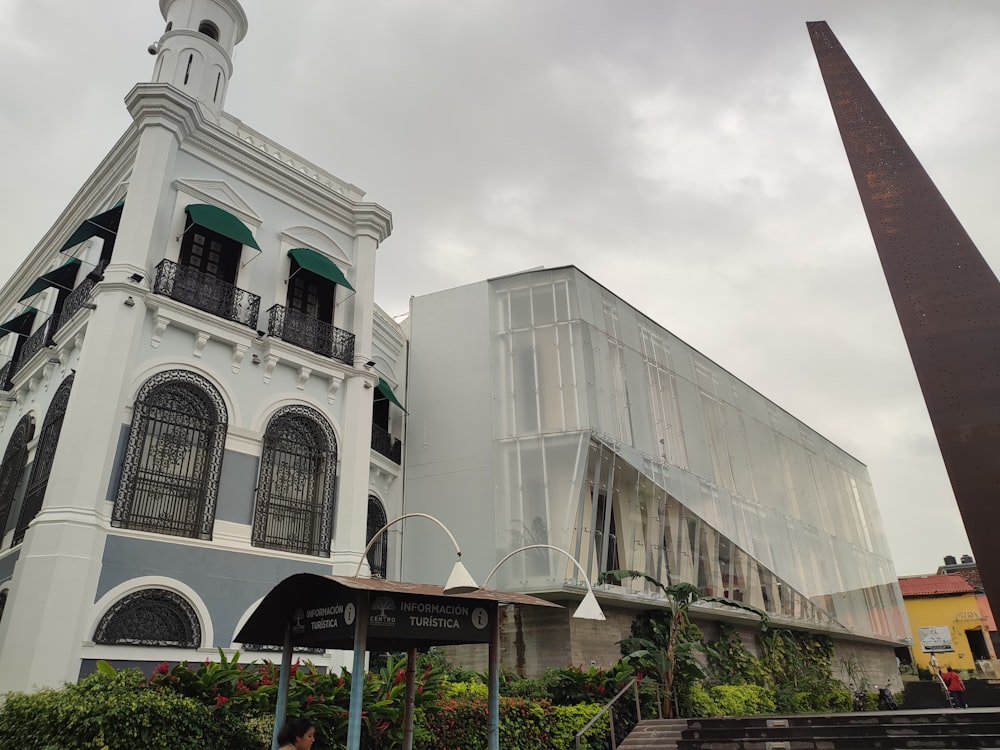 a tall white building with a clock tower next to it