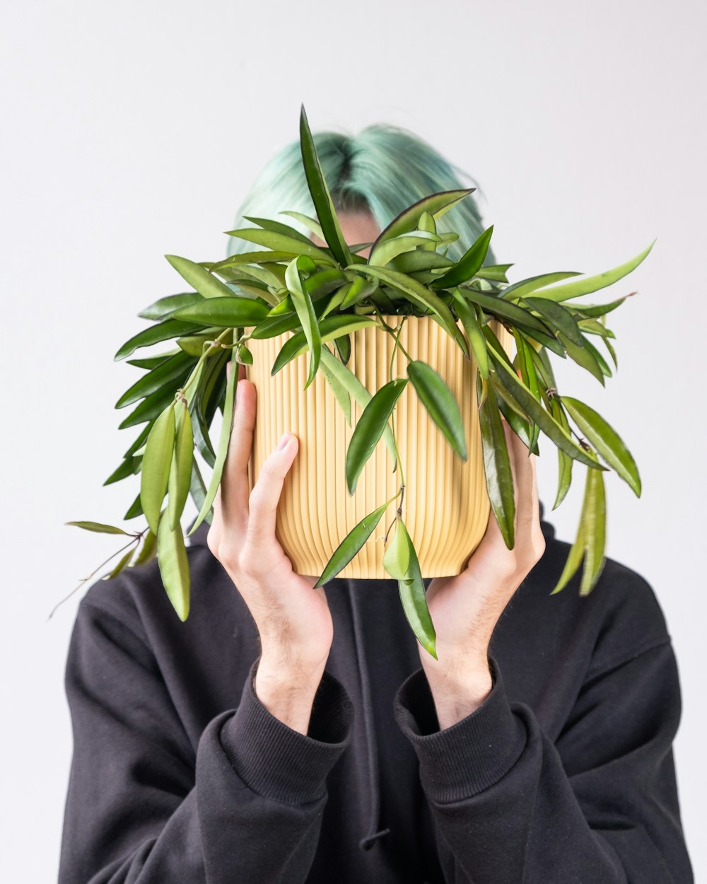 a person holding a plant in front of their face