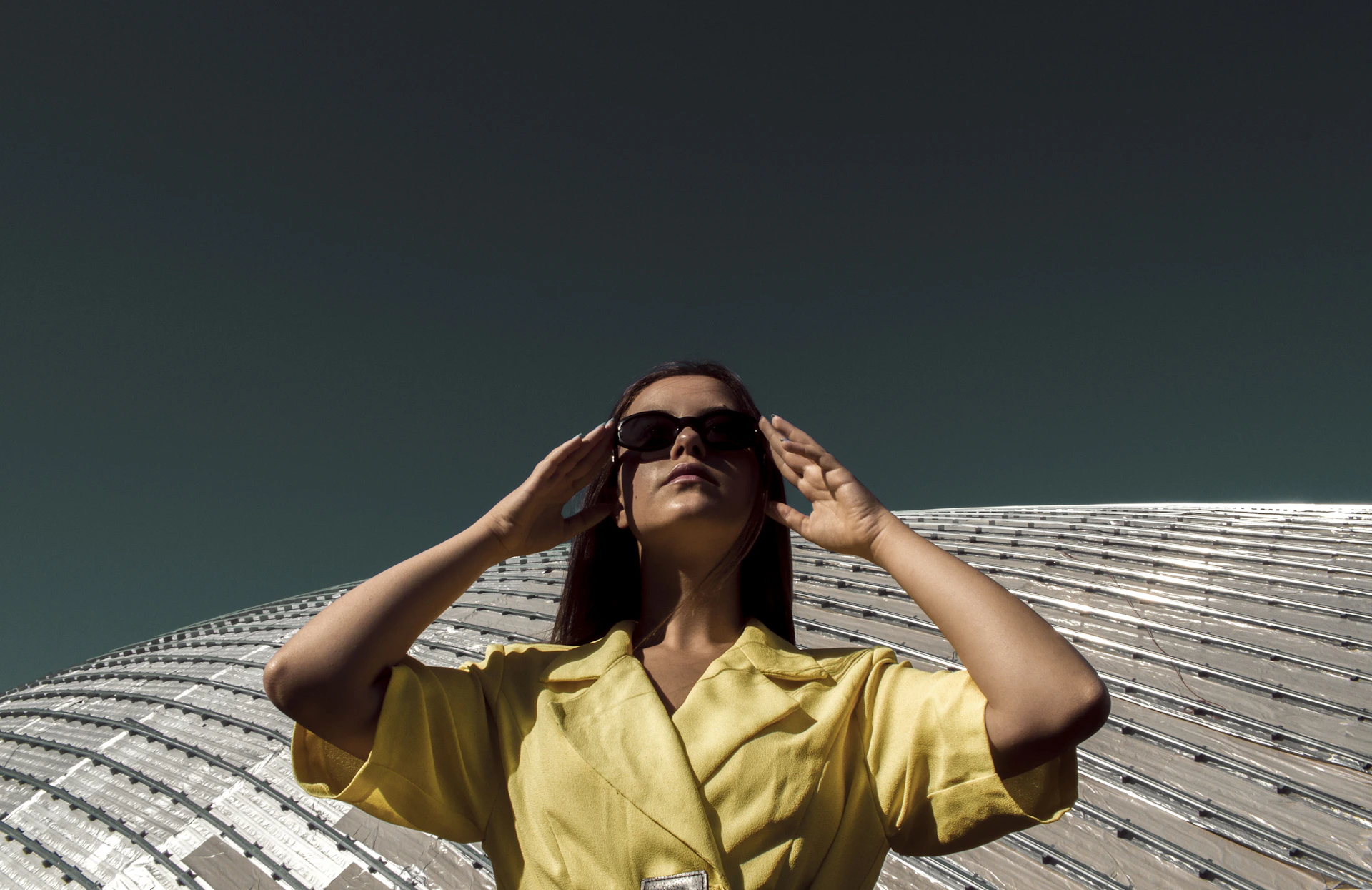 a woman wearing a yellow shirt and sunglasses
