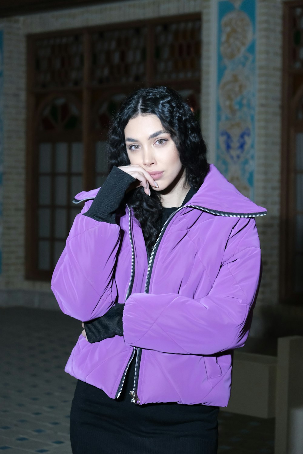 a woman in a purple jacket posing for a picture