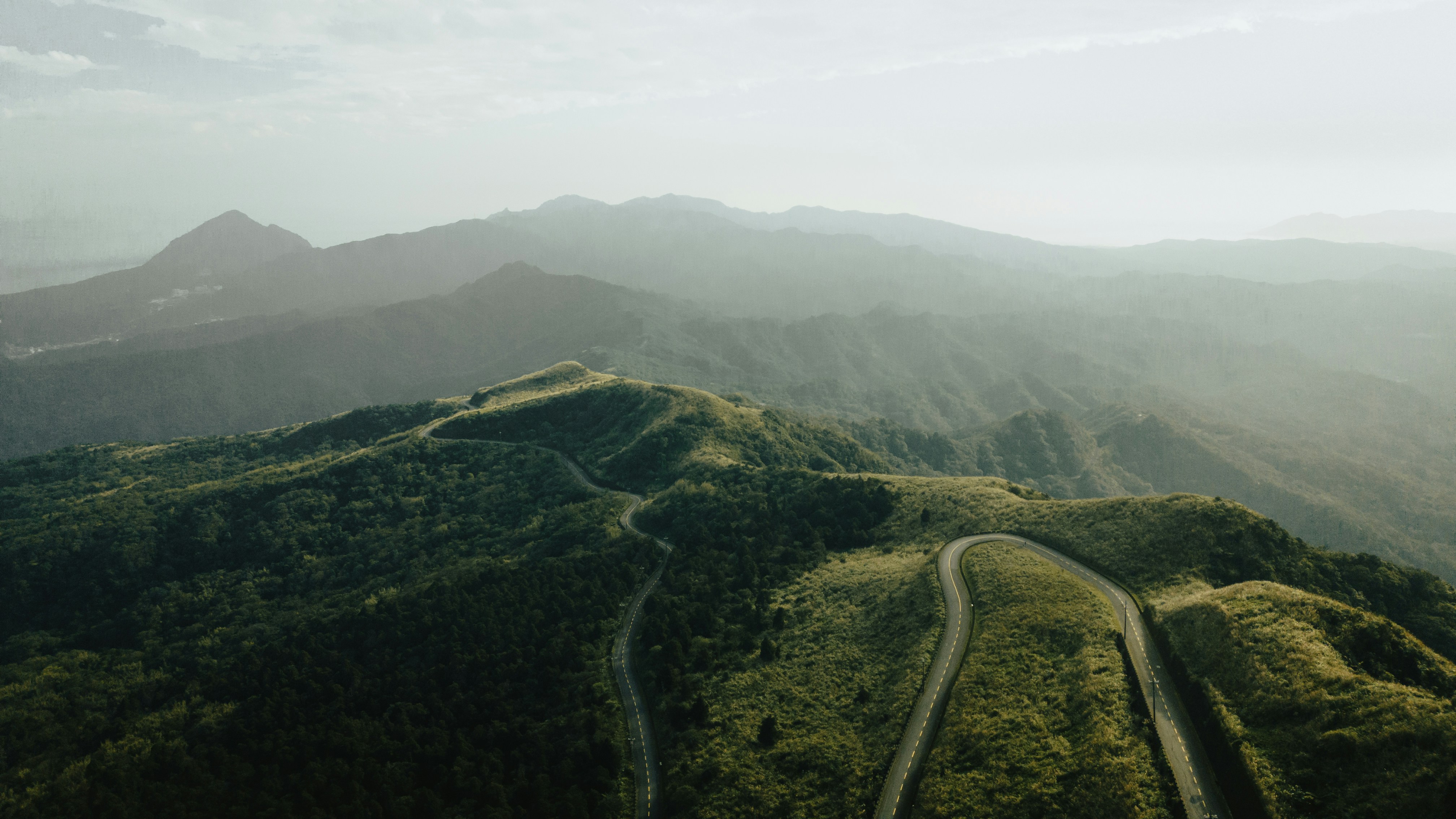 an aerial view of a winding road in the mountains
