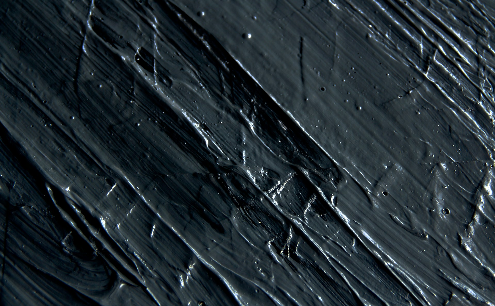 a close up of a black surface with water drops