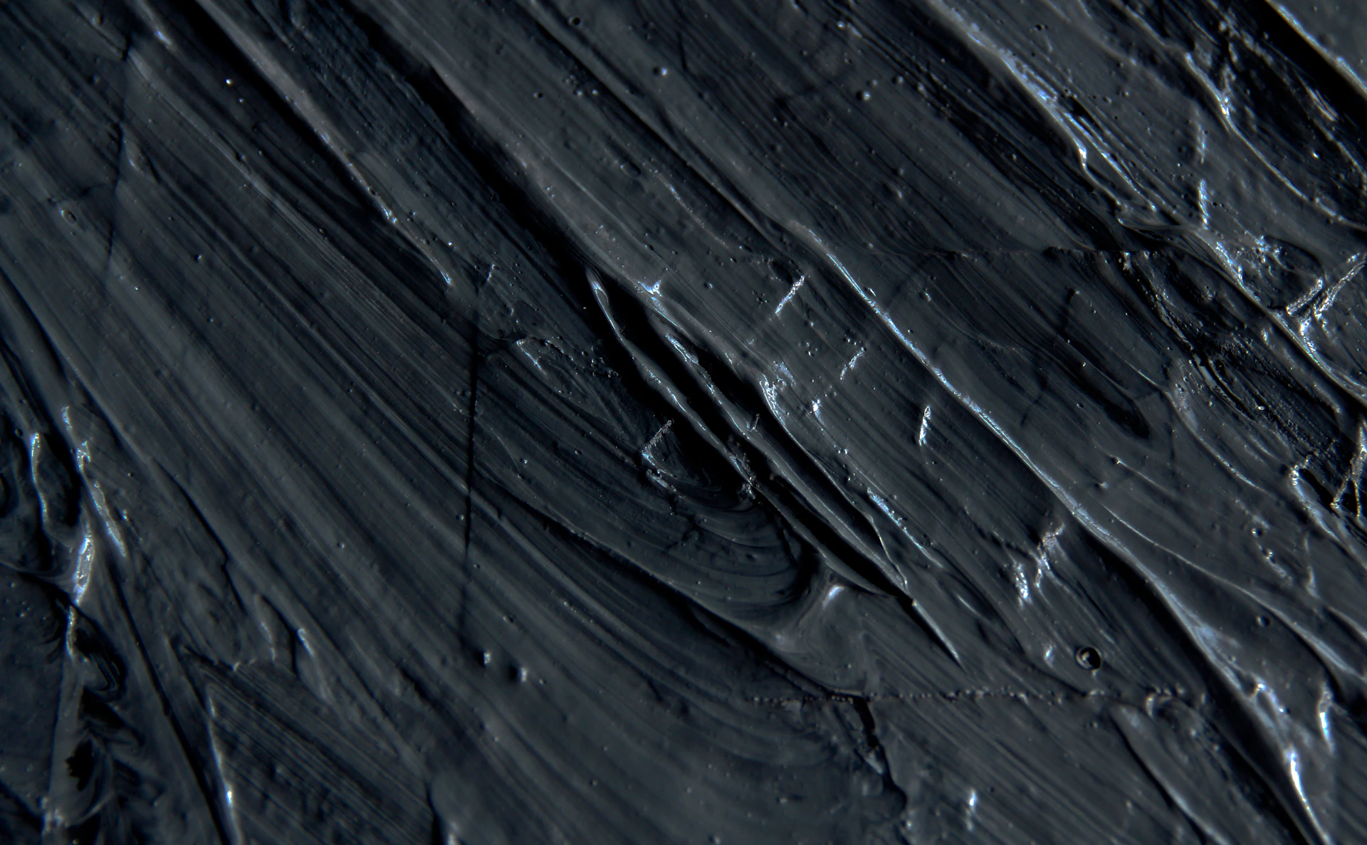 a close up of a black surface with water droplets