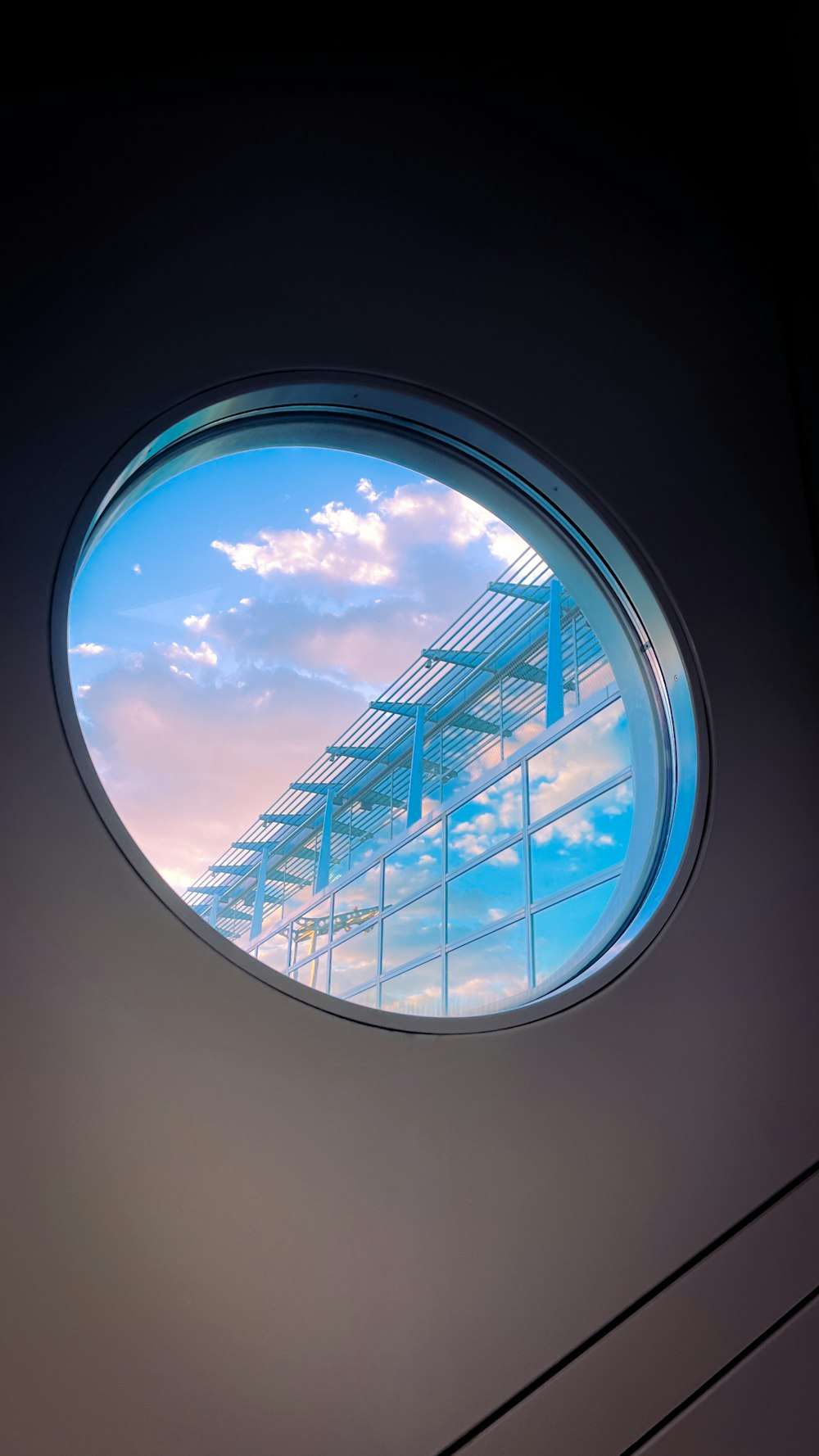 a round window with a sky reflection in it