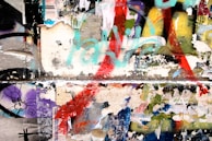 A finished collage artwork displayed on a beige wall, showcasing textures and colors.