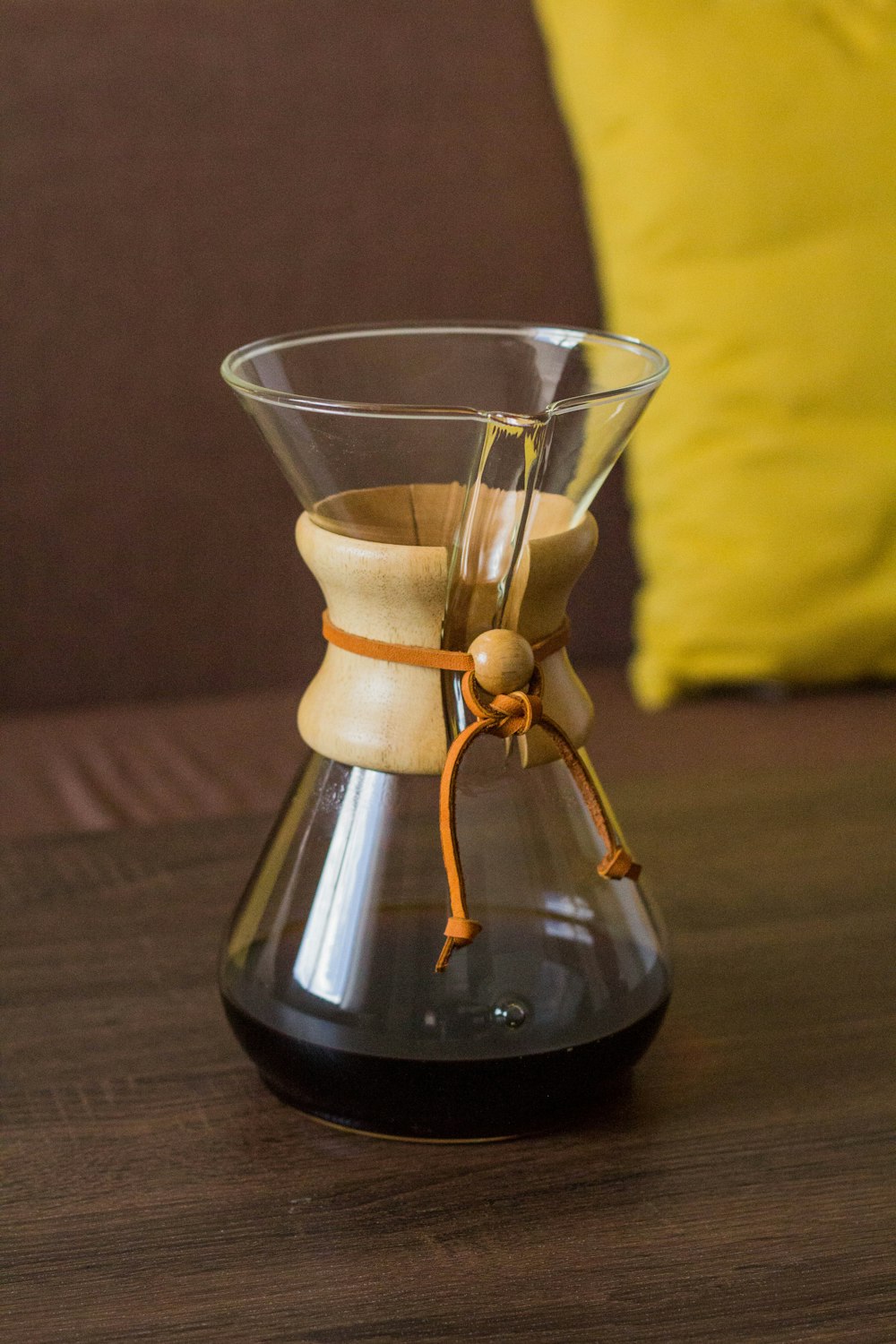 a coffee pot with a wooden handle on a table