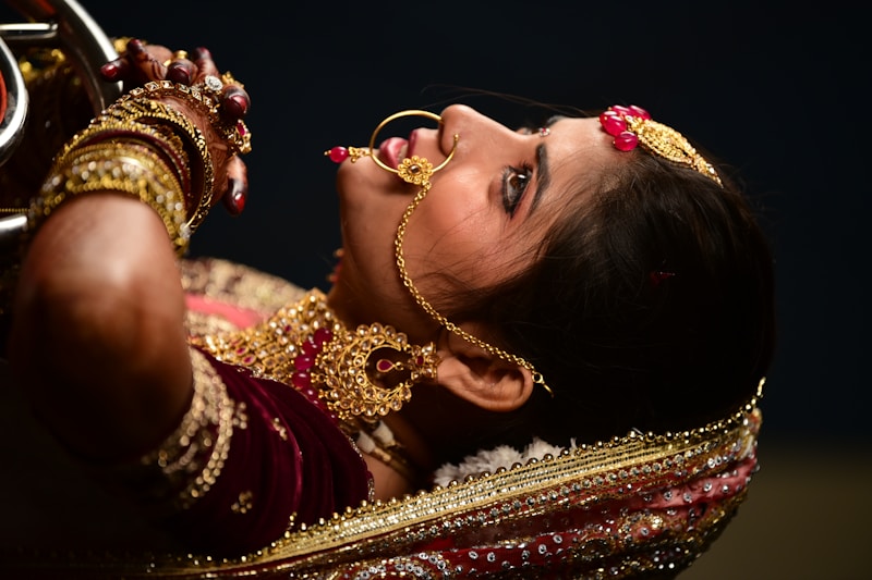 a woman in a red and gold outfit holding a mirror