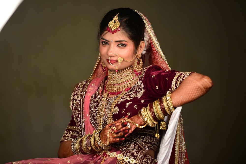 a woman in a red and gold bridal outfit