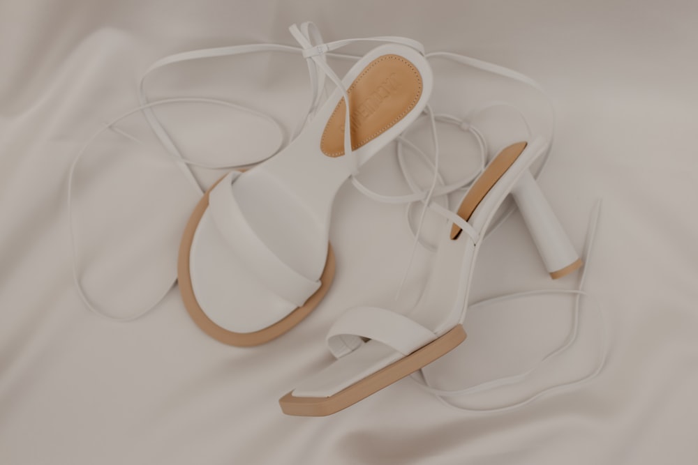 a pair of white shoes on a white sheet