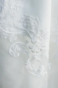 Delicate embroidery details featuring floral patterns on a soft mauve fabric.