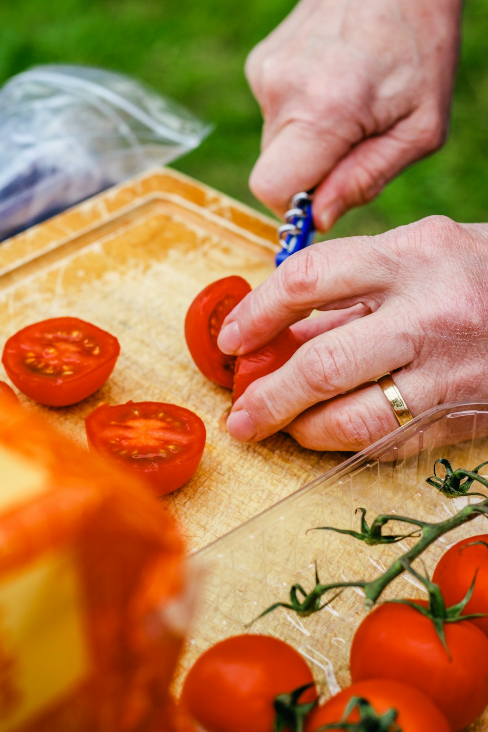 a person cutting tomatoes on a cutting board