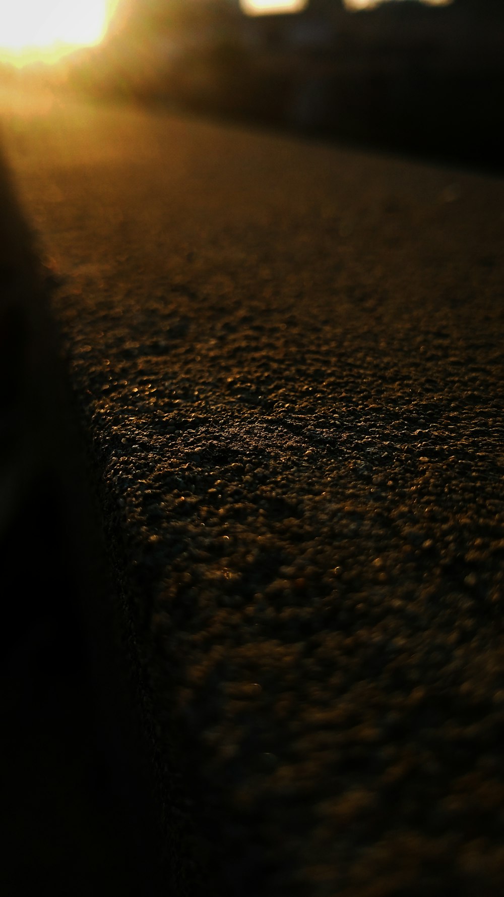 a close up of a street with the sun in the background