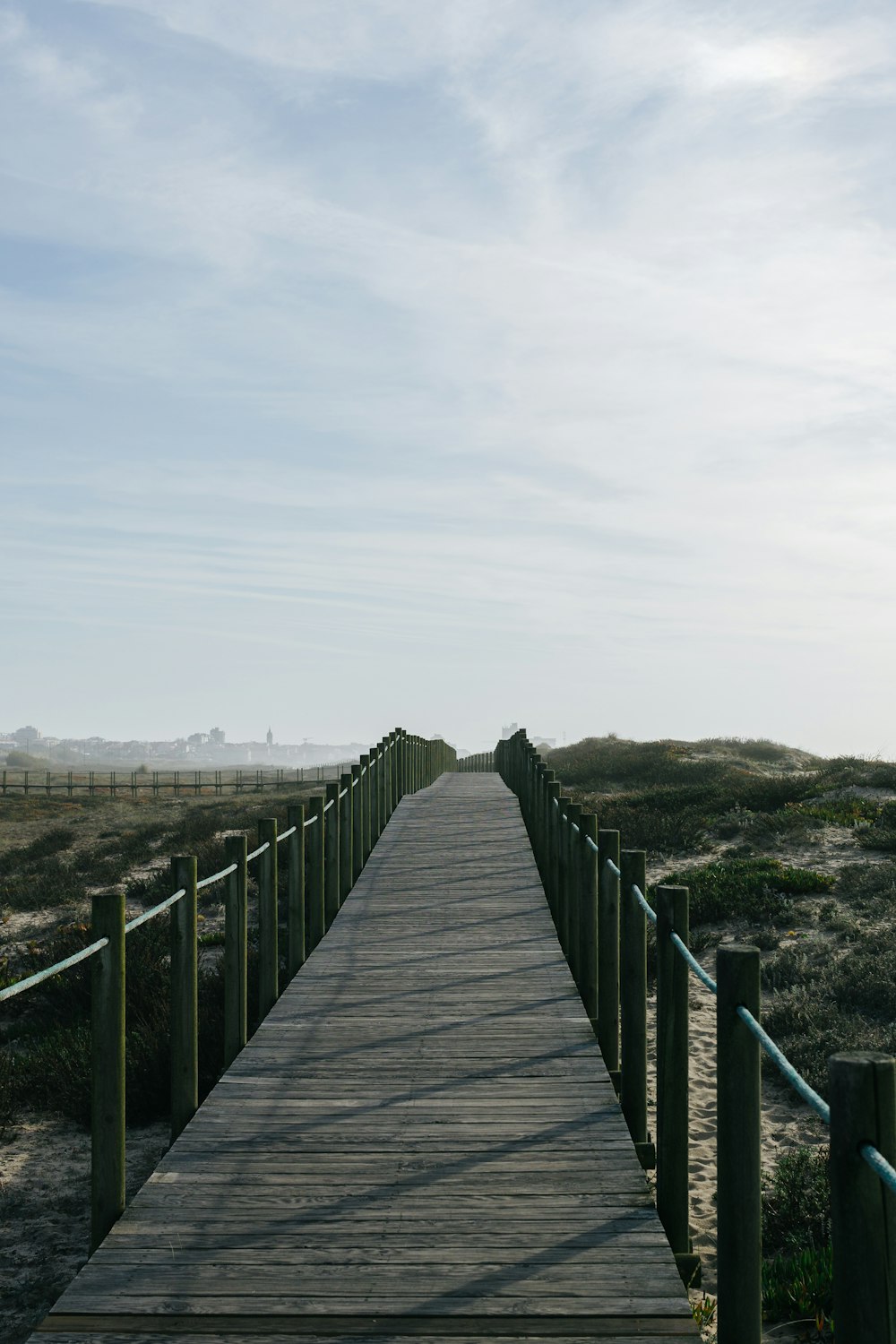a wooden walkway leading to a sandy beach