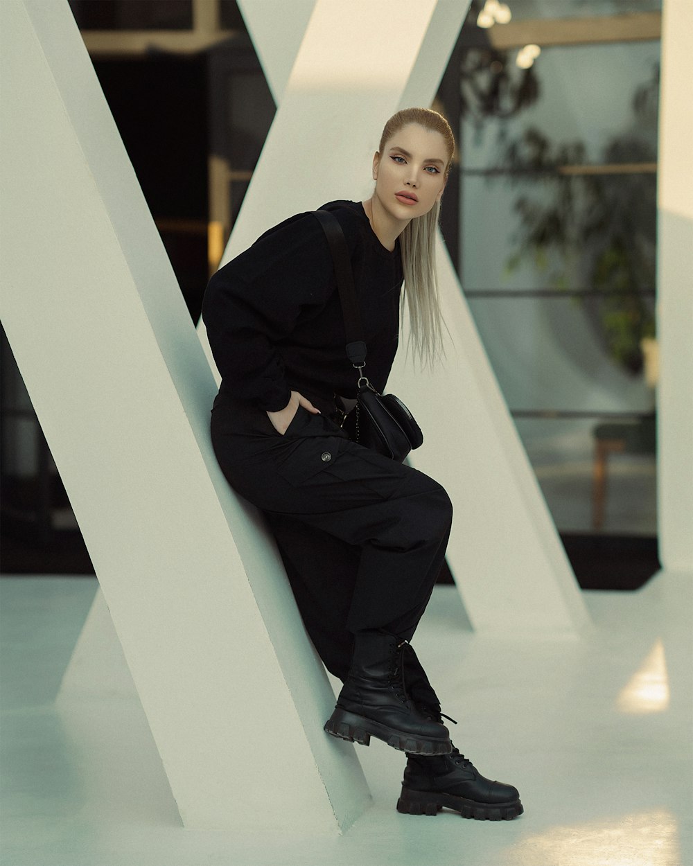 a woman sitting on a large white pillar